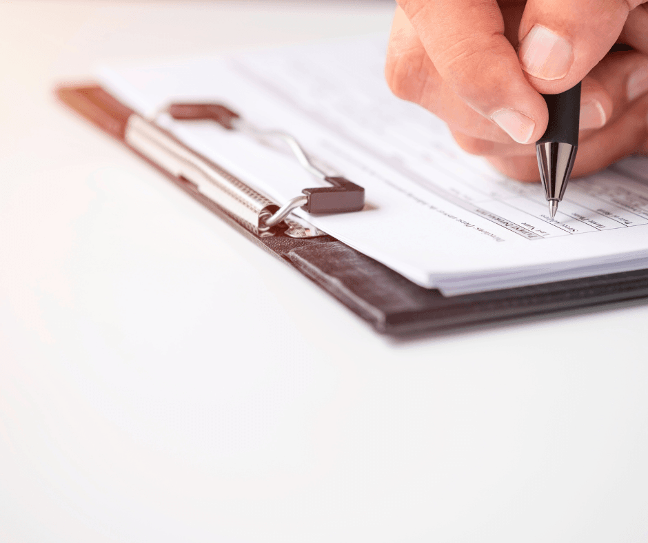 person's hand filling out a form with a pen