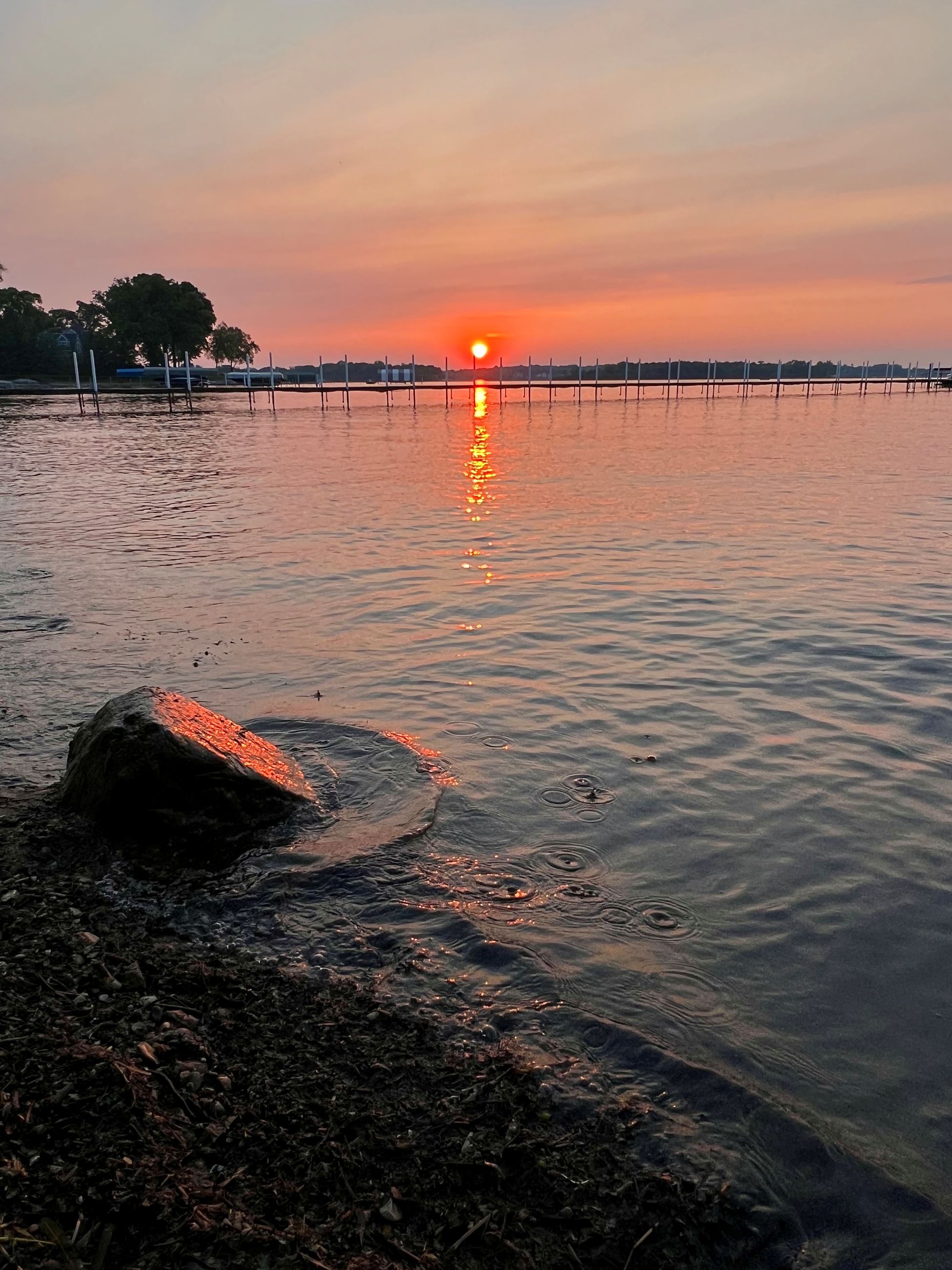 orange sunset over docks on a lake 
